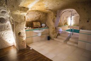 a bathroom in a cave with a sink and a tub at La Corte Dei Cavalieri in Matera