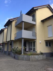 een groot geel gebouw met balkons in een straat bij Ferienwohnung Sobichowski in Rust