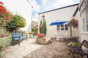 eine Terrasse mit Stühlen, einem Sonnenschirm und einem Tisch in der Unterkunft The Walnut Tree Hotel in Bridgwater