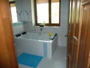 baño con bañera blanca y ventana en Villa Holiday, en Poroszló