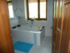 a white bath tub in a bathroom with a window at Villa Holiday in Poroszló
