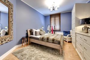 sypialnia z niebieskimi ścianami i dużym lustrem w obiekcie Lion Apartments MEWA w mieście Sopot