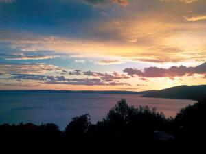 a sunset over a large body of water at Quercus Apartment in Stara Baška