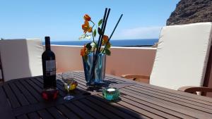 a table with a bottle of wine and a vase with flowers at Atico Orion Fibra 600 Mb in Casa Nueva