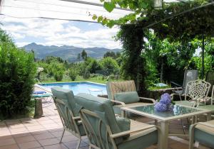 a patio with a table and chairs and a pool at Casa Anceu ArchsenseApartments. in Anceu