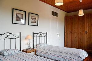 a bedroom with two beds and a wooden ceiling at Casa Anceu ArchsenseApartments. in Anceu +27 photos