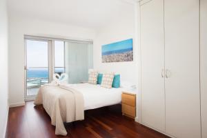 une chambre blanche avec un lit et une grande fenêtre dans l'établissement Rent Top Apartments Beach-Diagonal Mar, à Barcelone 106 autres photos
