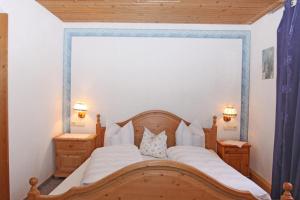 バッハにあるBeim Loisesのベッドルーム1室(木製ベッド1台、ナイトスタンド2台付)