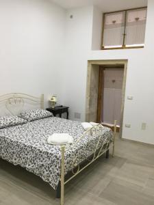 una camera da letto con un letto con un piumone bianco e nero di Casa Vacanze Ortigia a Siracusa