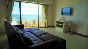 a living room with a couch and a television at VIP Condochain Rayong 427 in Ban Phe