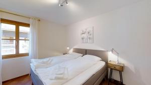 マローヤにあるLa Planüra 15の白いベッドルーム(ベッド1台、窓付)