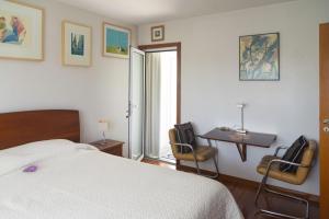 MurtosaにあるCasa da Magnóliaのベッドルーム1室(ベッド1台、テーブル、椅子付)