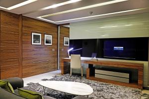a living room with a desk and a large tv at Warwick Stone 55 Hotel Beirut in Beirut