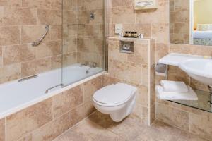 e bagno con servizi igienici, vasca e lavandino. di Old Weir Lodge a Killarney Altre 32 foto