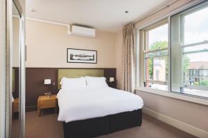 Un dormitorio con una cama grande y una ventana en The Wellington en Bristol