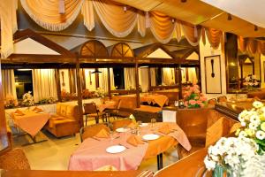 a restaurant with tables and couches and chairs at Hotel Poonja International in Mangalore