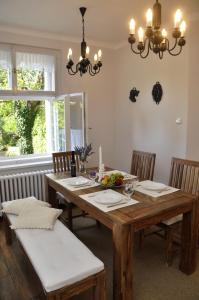 uma sala de jantar com uma mesa de madeira e cadeiras em Atmospheric Quiet Apartment em Praga