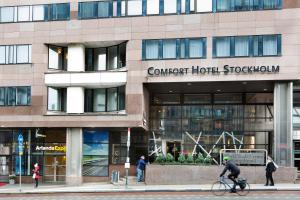 a man riding a bike in front of a building at Comfort Hotel Xpress Stockholm Central in Stockholm