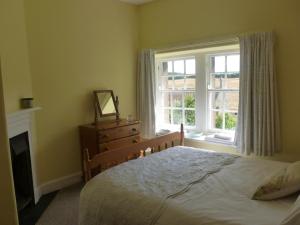 une chambre avec un lit et une fenêtre dans l'établissement The Cottage, à Etal