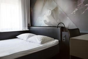 a bed with a white bedspread and pillows at Comfort Hotel Xpress Stockholm Central in Stockholm