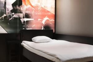 a hotel room with a large bed and a painting on the wall at Comfort Hotel Xpress Stockholm Central in Stockholm