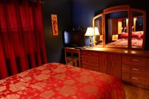 a bedroom with a bed and a dresser with a mirror at Magog Lovely Vacation Home in Magog-Orford