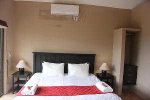 1 dormitorio con 1 cama con manta roja y blanca en Baleia Azul 15, en Ponta do Ouro