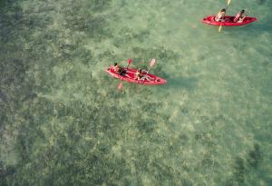 
three people in a canoe on a body of water at Nimmanoradee Resort - SHA PLUS Certified in Ko Samed
