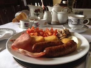 a plate of food with sausage and vegetables on a table at Mill House Bed and Breakfast in Cromer