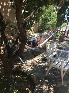 a man laying on a hammock under a tree at Kiveri Traditional Villa in Kiveri