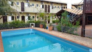 a swimming pool in front of a building at Hotel Refugio in Bonito