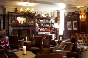 um bar com cadeiras de couro e uma lareira em The Crown Hotel em Blandford Forum