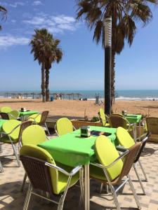 eine Gruppe von Tischen und Stühlen am Strand in der Unterkunft Aqua Nature 27D in La Mata