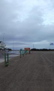 un estacionamiento con vallas verdes y un cartel en Guzmán, en Punta del Este