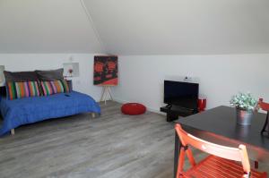 een slaapkamer met een bed en een flatscreen-tv bij Lisbon Beach Apartments 5 in Costa da Caparica
