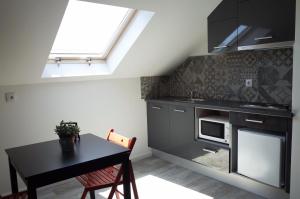 a kitchen with a table and a stove and a window at Lisbon Beach Apartments 5 in Costa da Caparica