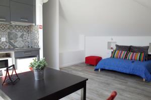 ein Wohnzimmer mit einem Bett und einem Tisch in der Unterkunft Lisbon Beach Apartments 5 in Costa da Caparica