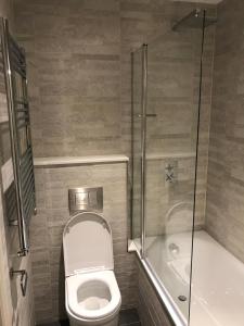 a small bathroom with a toilet and a shower at The Coffee House Hotel in Aberdeen