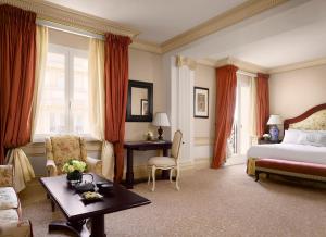 モンテカルロにあるHôtel Métropole Monte-Carloのベッドとテーブルのあるホテルの部屋