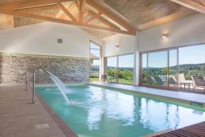 uma piscina com cascata numa casa em Hotel Spa Les Rives Sauvages em Malbuisson