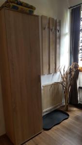 un gran armario de madera en una habitación con cuna en Ferienwohnung Weiser, en Cuxhaven