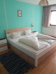 un grande letto in una camera da letto con parete blu di Landgasthof Astner a Münster