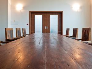 een grote houten tafel in een kamer met stoelen bij Hotel Alfa in Třebíč