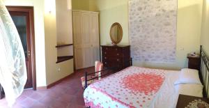 a bedroom with a bed and a dresser and a mirror at B&B La Casa Vecchia in Gallo