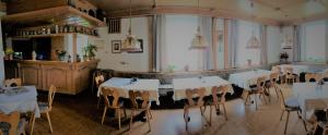 uma sala de jantar com mesas e cadeiras brancas em Hotel Bergblick em Warmensteinach