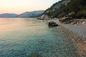 a body of water with a rocky shore at Quercus Apartment in Stara Baška
