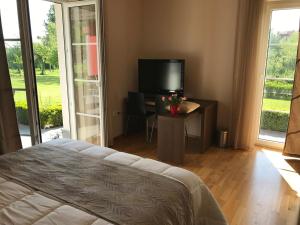 a bedroom with a bed and a television and a table at Linden Garden Apartment in Postojna