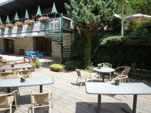 patio con mesas y sillas y balcón en Chalet du Montal, en Dun-les-Places