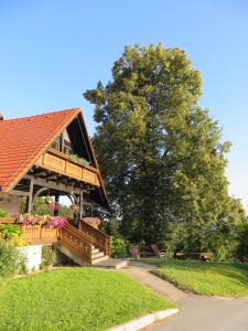 a house with a deck with flowers on it at Country House Apat in Šoštanj