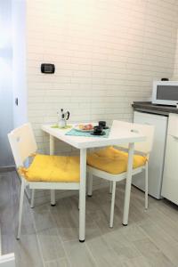ナポリにあるO Vascetielloの白いテーブルと椅子2脚付きのキッチン
